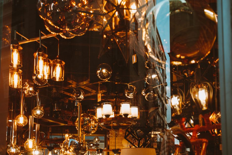 A cozy display of various illuminated lamps with warm lighting, reflecting urban architecture.